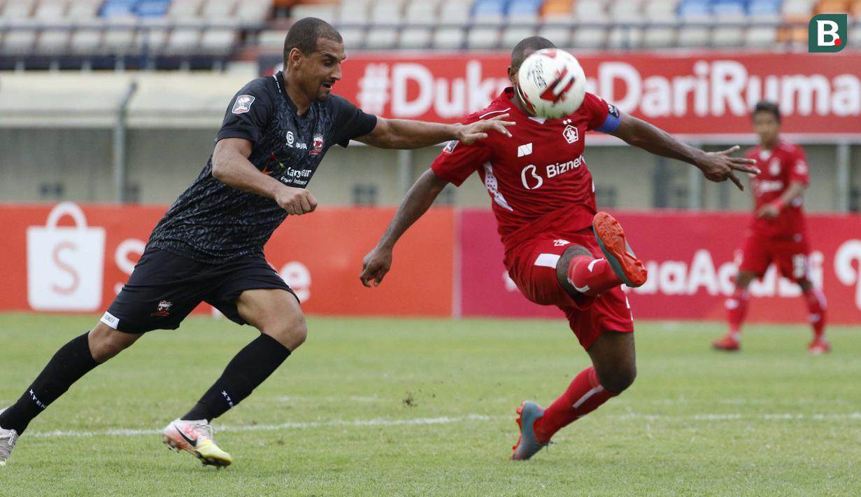 Bek Persik Kediri, Andri Ibo (kanan) menghalau bola saat dibayangi striker Madura United, Bruno Da Silva Lopes dalam laga Grup C Piala Menpora 2021 di Stadion Si Jalak Harupat, Bandung, Sabtu (3/4/2021). Persik menang 2-1 atas Madura United. (Bola.com/Ikhwan Yanuar)