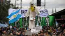 Demonstran membawa boneka hantu saat demonstrasi menentang kebijakan Presiden Mauricio Macri di Buenos Aires, Argentina, Senin (9/7). Demonstran meneriakkan yel-yel "Tanah Air tidak pernah menyerah." (Eitan ABRAMOVICH/AFP)