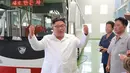 Pemimpin Korea Utara Kim Jong-Un berbincang selama kunjungan ke pabrik bus di Pyongyang, Korea Utara, (4/8). Dalam kunjungannya Kim Jong-un juga melihat langsung proses produksi bus. (AFP Photo/KCNA)