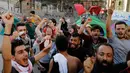 Para pengunjuk rasa anti-pemerintah bergembira setelah PM Lebanon Saad Hariri mengumumkan pengunduran dirinya, di depan istana pemerintahan di Beirut, Selasa (29/10/2019). PM Hariri mengundurkan diri setelah berlangsung aksi unjuk rasa besar-besaran dalam dua minggu terakhir. (AP/Bilal Hussein)