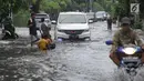 Kendaraan melintasi banjir di kawasan Green Garden, Jakarta Barat, Selasa (5/3). Sejumlah ruas jalan di Jakarta Barat tergenang air akibat luapan Kali Angke dan drainase yang buruk serta pasang air laut. (merdeka.com/Arie Basuki)