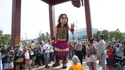 Little Amal, boneka yang menggambarkan gadis pengungsi Suriah di depan markas PBB di Jenewa, Selasa (28/9/2021). Boneka raksasa ini menyampaikan pesan untuk membangkitkan kesadaran akan krisis pengungsi dan penderitaan jutaan anak yang telantar di penjuru dunia. (Salvatore Di Nolfi/Keystone via AP)