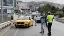 Polisi menghentikan taksi di pos pemeriksaan di Istanbul, Turki, Rabu (8/7/2020). Polisi menghentikan angkutan umum di beberapa pos pemeriksaan untuk memantau apakah pengemudi mengikuti aturan jaga jarak sosial, memakai masker, dan mematuhi langkah-langkah kebersihan. (Xinhua/Osman Orsal)