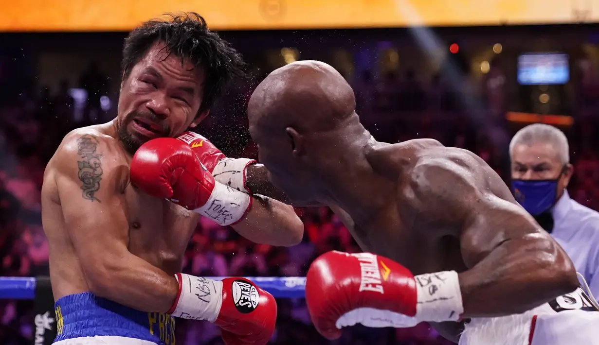 Yordenis Ugas dari Kuba saat memukul Manny Pacquiao, dari Filipina, dalam duel perebutan sabuk juara WBA super kelas welter di Las Vegas, Minggu (22/8/2021). Ugas menang angka atas Pacquiao 115-113, 116-112, dan 116-112. (AP Photo/John Locher)