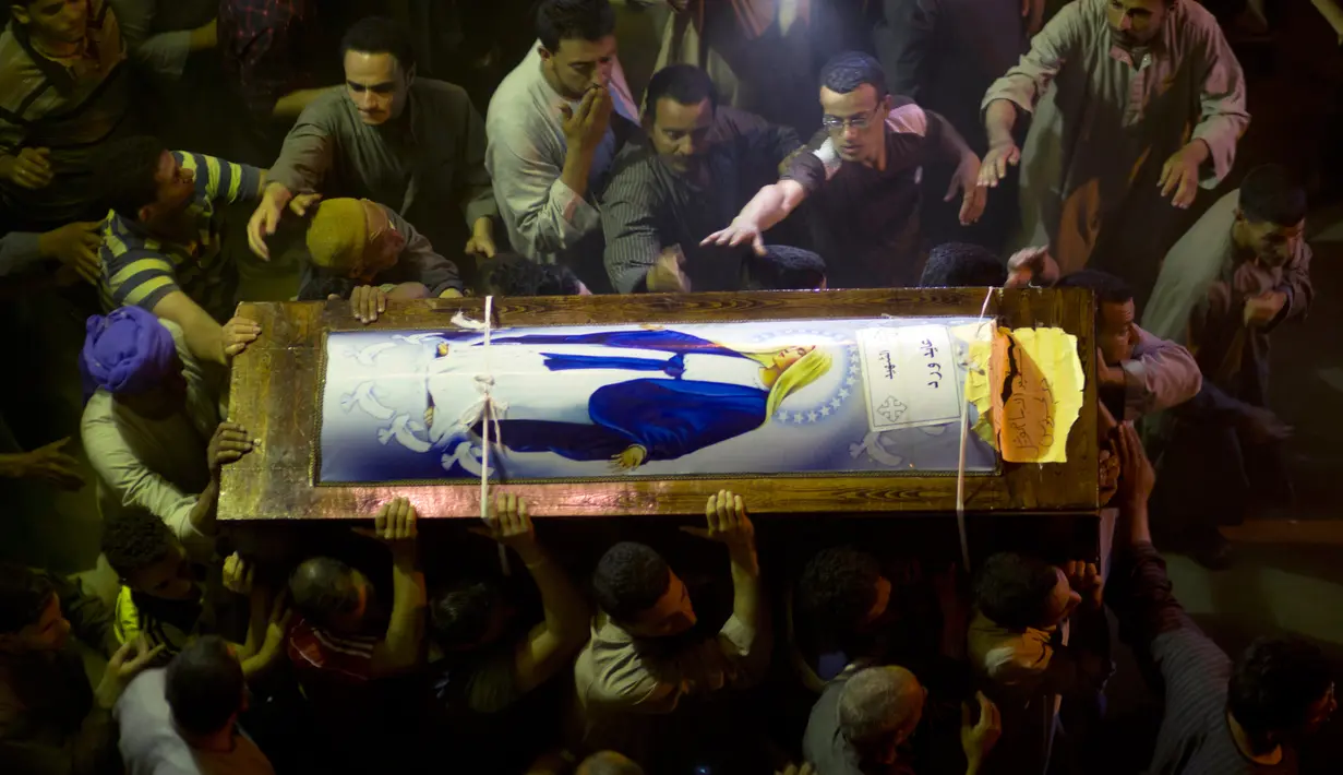 Kerabat Kopral Christian Ayied Ward, yang merupakan korban serangan terhadap sebuah bus, membawa peti mati mengikuti layanan pemakamannya di Katedral Abu Garnous di Minya, Mesir, (26/5).  (AP Photo / Amr Nabil)