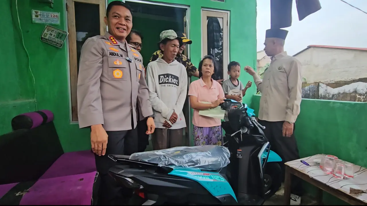 Kapolres Metro Depok Kombes Abdul Waras memberikan sepeda motor kepada penjual es kue jadul Sudrajat. (Liputan6.com/Dicky Agung Prihanto)