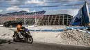 Sebuah sepeda motor melintasi di dekat bangunan yang runtuh pascagempa berkekuatan magnitudo 7,7 di Borong, Manggarai Timur, Nusa Tenggara Timur, Minggu, 16 Agustus 2026.. (AFP/ Juni Kriswanto)