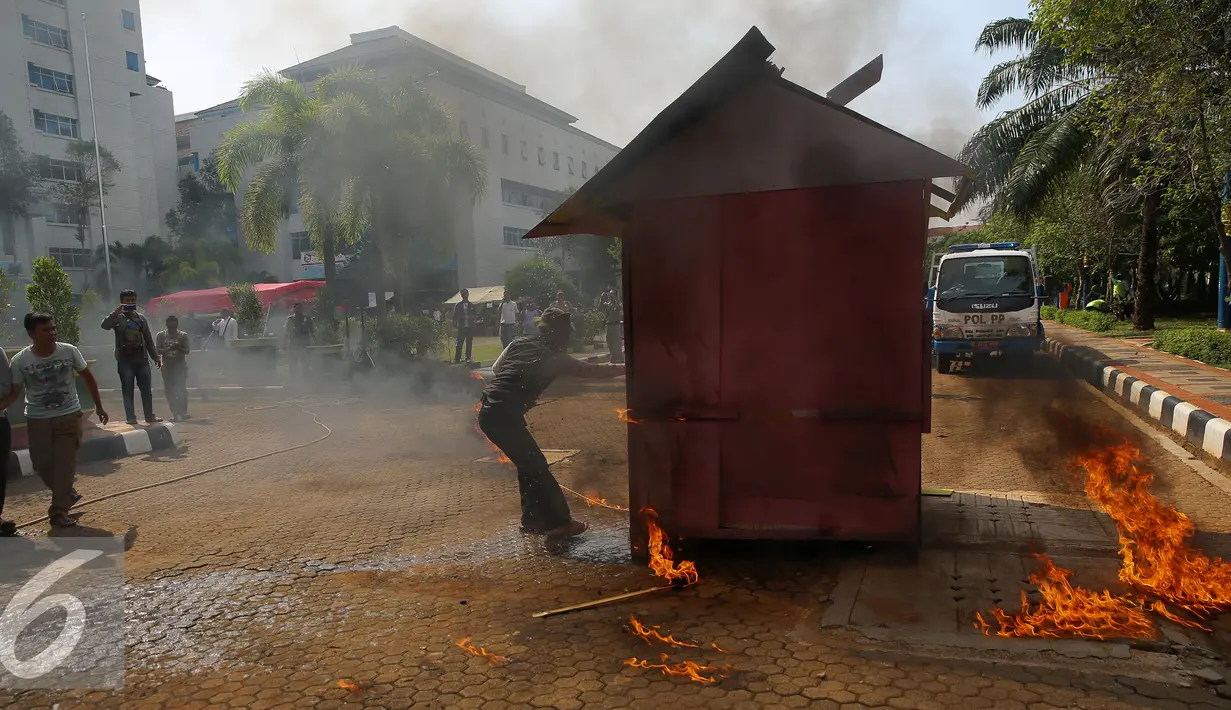 Petugas dan warga berusaha memadamkan api saat simulasi penanganan bencana di Jakarta, Kamis (10/12). Guna mengantisipasi banjir khususnya pada musim penghujan dan air pasang, berbagai persiapan dilakukan Pemkot Jakarta Utara. (Liputan6.com/Faizal Fanani)