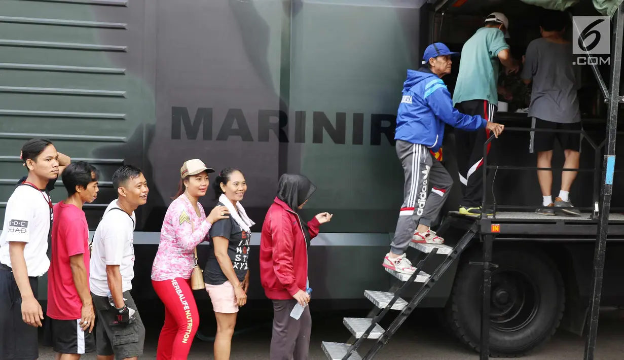Warga mengantre nasi goreng gratis ala prajurit Korps Marinir TNI AL saat car free day di Jakarta, Minggu (5/11). Kegiatan bagi-bagi nasi goreng ini dalam rangka menyambut HUT Marinir ke-72. (Liputan6.com/Angga Yuniar)