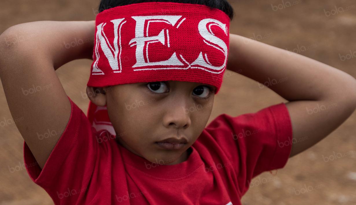 Seoarang anak memakai ikatan kepala saat mau mendukung Timnas Indonesia yang akan bertanding melawan Vietnam di Stadion Pakansari, Jawa Barat, Sabtu (3/12/2016). (Bola.com/Vitalis Yogi Trisna)