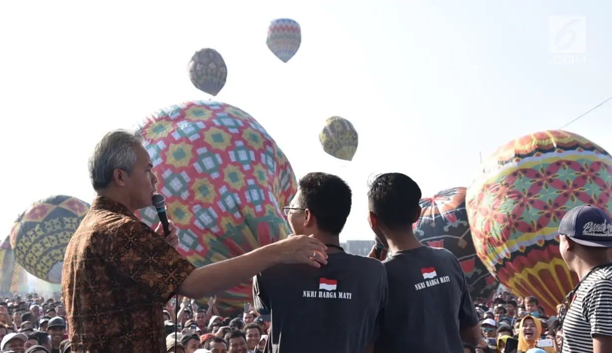 Gubernur Jawa Tengah Ganjar Pranowo (kiri) berbincang dengan warga saat membuka Java Balon Festival di Stadion Hoegeng, Pekalongan, Jawa Tengah, Rabu (12/06/2019). Java Balon Festival sebagai ungkapan rasa syukur warga Pekalongan saat  acara Syawalan. (Liputan6.com/Gholib)