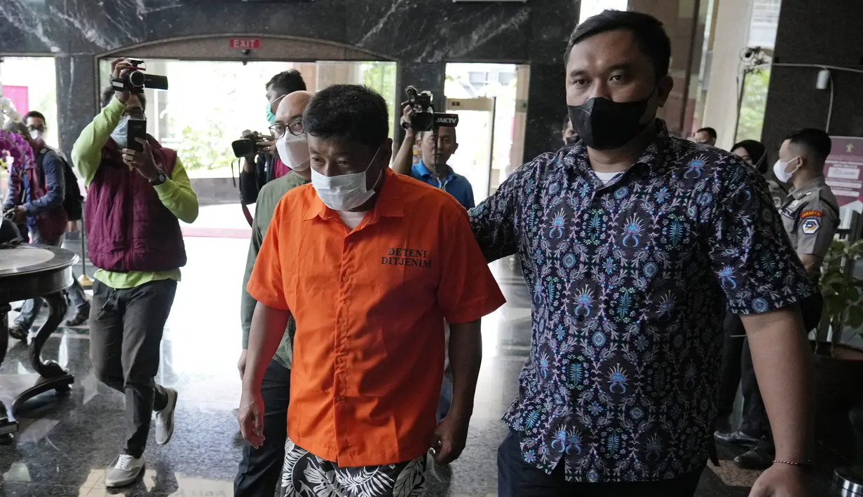 Petugas imigrasi mengawal Mitsuhiro Taniguchi (47) sebelum konferensi pers di Kantor Imigrasi, Jakarta, Indonesia, Rabu (8/6/2022). Penangkapan Mitsuhiro Taniguchi dilakukan pukul 22.30 WIB, kemarin. (AP Photo/Achmad Ibrahim)