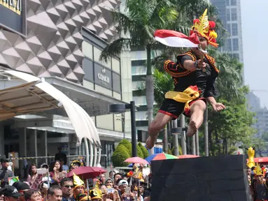 Salah satu pemuda peduli Nias melakukan atraksi lompat batu di kawasan Jalan Jenderal Sudirman, Jakarta, Minggu (4/3). Pemuda Peduli Nias melakukan beragam atraksi budaya untuk mempromosikan pariwisata di pulau tersebut. (Liputan6.com/Helmi Fithriansyah)