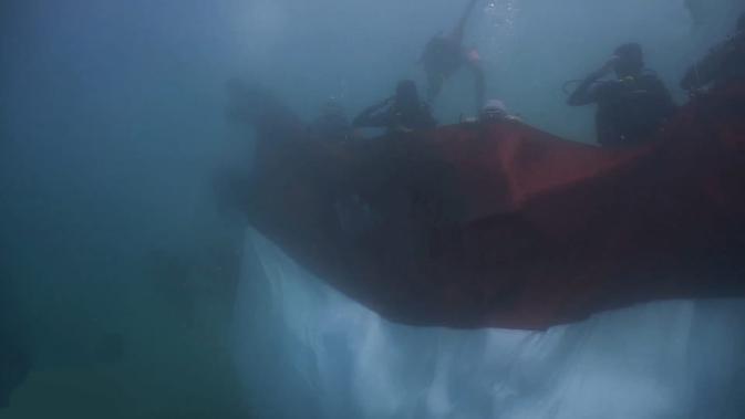 Pengibaran bendera merah putuh bawah laut Tanjung Kajuwulu oleh 20 penyelam. (Liputan6.com/Dionisius Wilibardus)