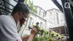 Pekerja membersihkan salib jelang ibadah Natal di Gereja Katedral, Jakarta, Senin (20/12/2021). Sejumlah persiapan dan pemasangan dekorasi mulai dilakukan pihak Gereja Katedral untuk menyambut misa dan perayaan Natal. (Liputan6.com/Faizal Fanani)
