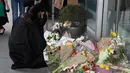 Meghan Markle meletakkan karangan bunga sebagai penghormatan kepada para korban serangan teror di Christchurch saat bersama sang suami, Pangeran Harry, mengunjungi New Zealand House di London, Selasa (19/3). (AP/Alastair Grant)
