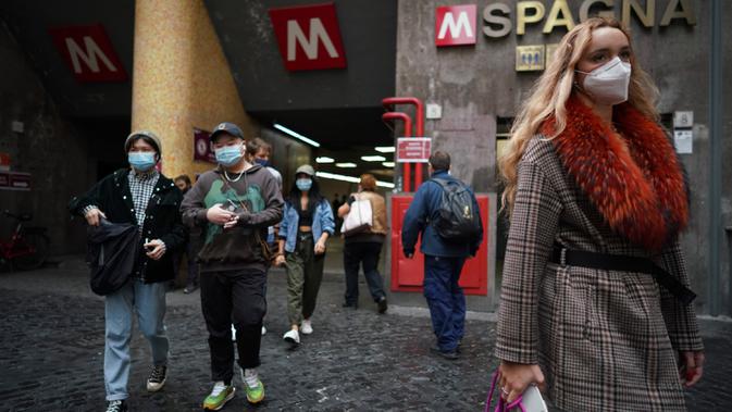 Orang-orang memakai masker saat berjalan keluar dari stasiun subway di Roma pada Sabtu (3/10/2020). Mulai Sabtu, masker wajah harus dipakai setiap saat di luar rumah di ibu kota Italia, Roma dan wilayah sekitar Lazio untuk meredam infeksi Covid-19 yang meningkat. (AP Photo/Andrew Medichini)