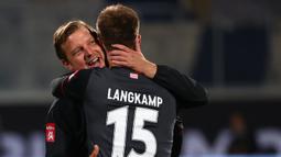 Pelatih Werder Bremen, Florian Kohfeldt, memeluk Sebastian Langkamp setelah timnya berhasil bertahan di kompetisi Bundesliga usai menahan imbang Heidenheim 1846 di laga play-off leg kedua, Selasa (7/7/2020) dini hari WIB. Bremen bermain imbang 2-2 atas Heidenheim. (AFP/Kai Pfaffenbach/pool)