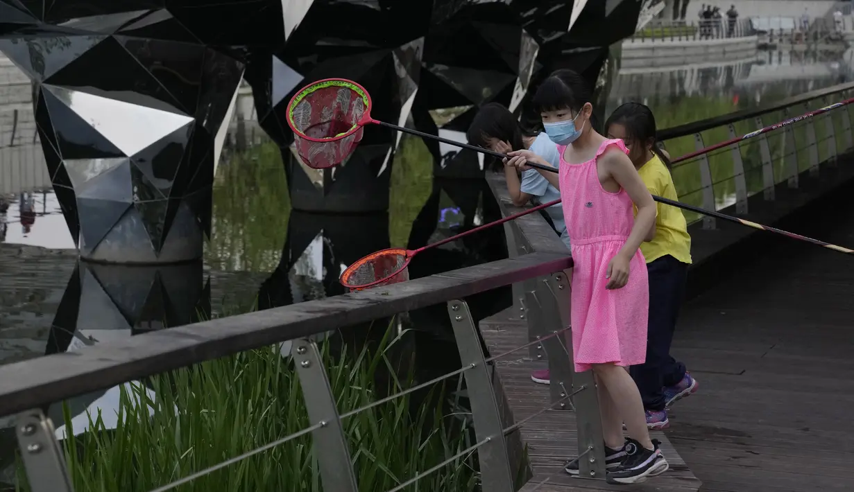 <p>Warga yang memakai masker menikmati hari di sebuah taman di Beijing, Rabu (18/5/2022). Sebagian besar Beijing di-lockdown, tetapi jalan-jalan jauh lebih sepi dari biasanya dengan banyak toko tutup dan orang-orang bekerja dari rumah ketika ibu kota China mencoba mengendalikan wabah COVID-19 yang kecil tetapi terus-menerus. (AP Photo/Ng Han Guan)</p>