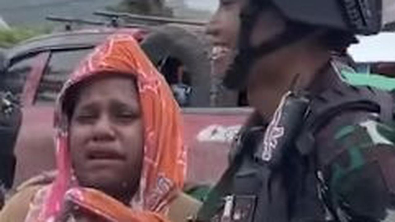 "Aku sedih sekali ini," ujar wanita ini berdiri di samping prajurit TNI sembari menangis sesengukan.<br>