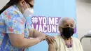 Seorang perempuan menerima dosis vaksin COVID-19 Pfizer-BioNTech di pusat vaksinasi di Santiago, Chile, Senin (10/1/2022). Chile mulai memberikan dosis keempat vaksin COVID-19 kepada warga berusia di atas 12 tahun yang mengalami gangguan kekebalan. (Javier TORRES / AFP)