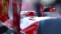 Refleksi pebalap Ferrari, Kimi Raikkonen, dari spion mobilnya saat latihan bebas pertama dalam F1 GP Abu Dhabi di Sirkuit Yas Marina, Abu Dhabi, (27/11/2015). (AFP/Andrej Isakovic)