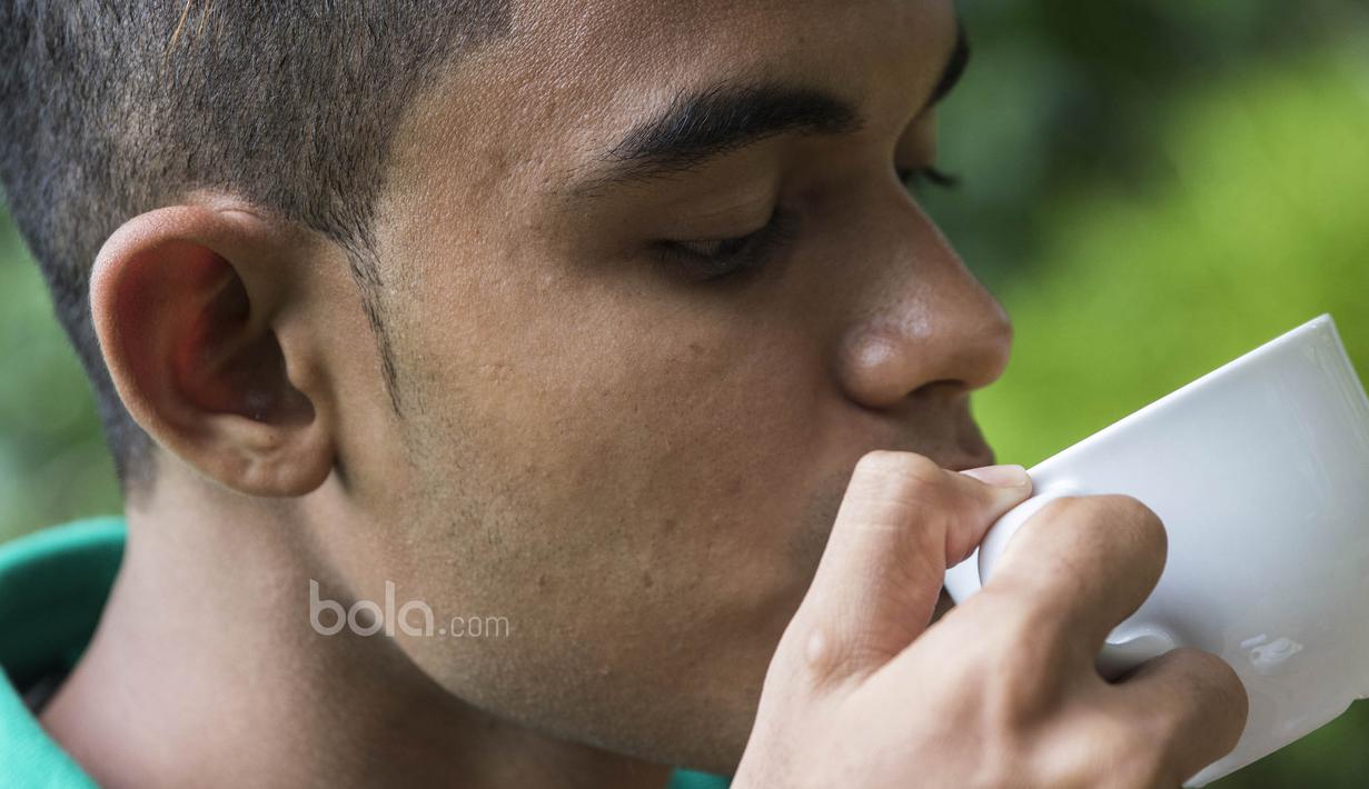 Gelandang Timnas Indonesia U-22, Miftahul Hamdi, menyeruput secangkir teh di Hotel Sthala, Bali, Sabtu (8/7/2017). Pemain Bali United ini sedang mengikuti pemusatan latihan jelang SEA Games. (Bola.com/Vitalis Yogi Trisna)