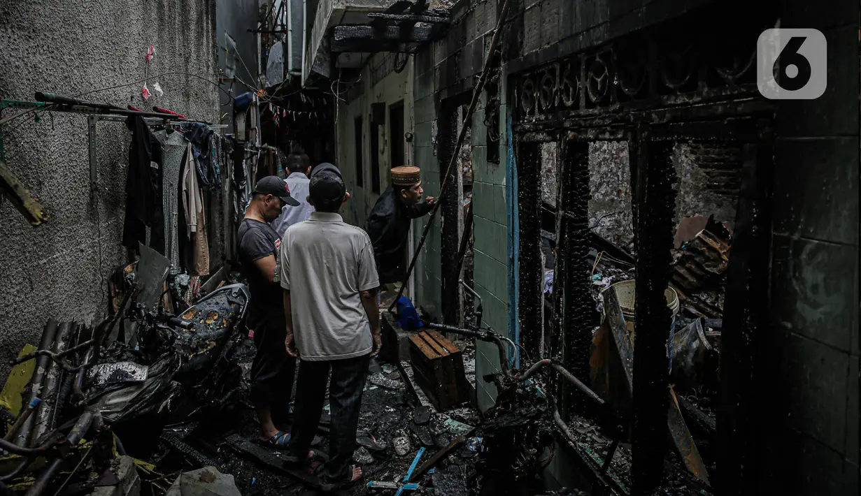 Warga mengecek kondisi rumah yang terbakar di Jalan Keagungan, RW 07, Kelurahan Keagungan, Kecamatan Taman Sari, Jakarta Barat, Rabu (3/1/2024). (Liputan6.com/Faizal Fanani)