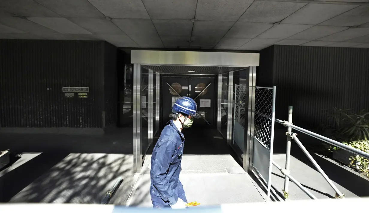 Seorang pekerja berjalan melalui lokasi pembongkaran Menara Kapsul Nakagin, bangunan ikonik yang dirancang arsitek Jepang Kisho Kurokawa pada tahun 1972, di distrik Ginza Tokyo, Selasa (12/4/2022). Pekerjaan pembongkaran menara 140 unit kapsul tersebut dimulai Selasa. (AP Photo/Eugene Hoshiko)