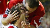 Wayne Rooney memberi selamat kepada Ruud van Nistelrooy saat membantu Manchester United (MU) mengakhiri laju tidak terkalahkan Arsenal. (AFP/Magi Haroun)