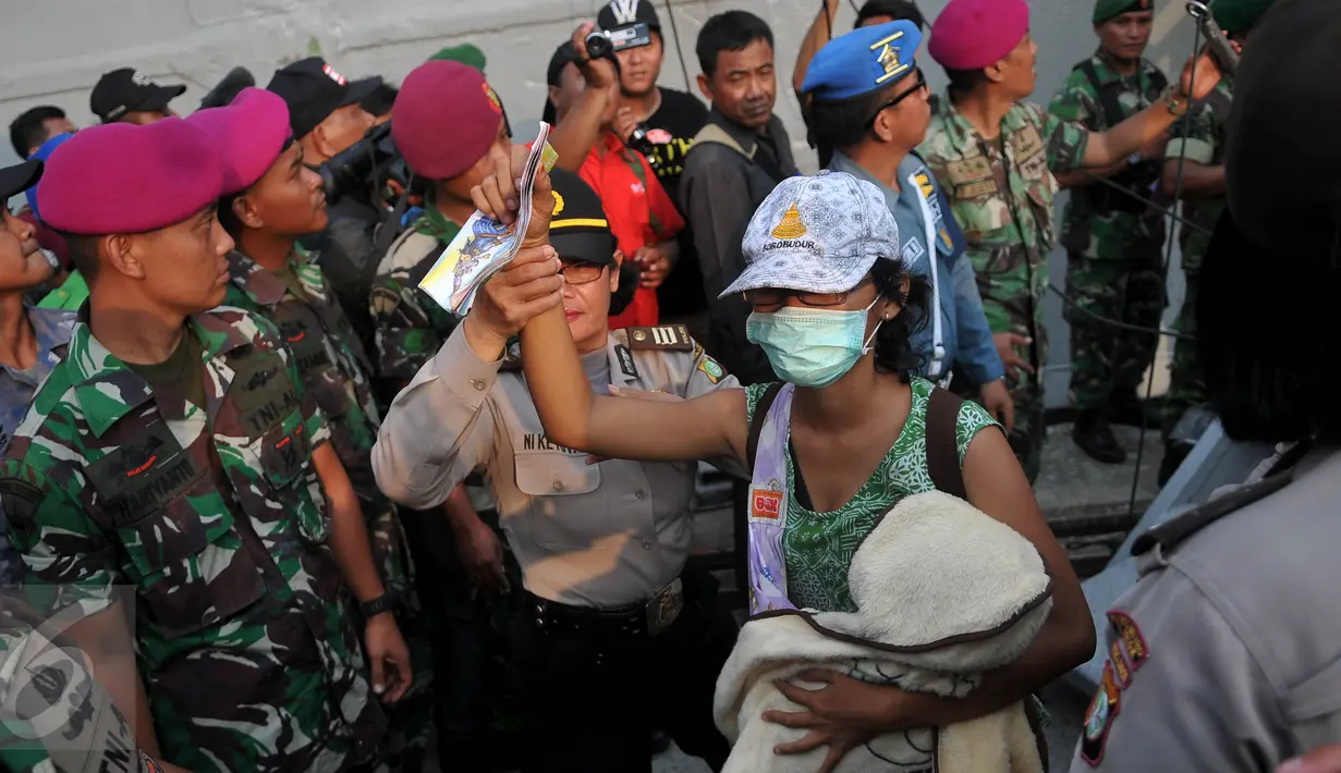 Petugas membantu warga eks Gafatar menuruni tangga kapal saat tiba di Pelabuhan Tanjung Priok, Jakarta, Kamis (28/1/2016). Sebanyak 824 warga eks Gafatar dipulangkan dari Kalimantan untuk dikembalikan ke daerah asal. (Liputan6.com/Gempur M Surya)
