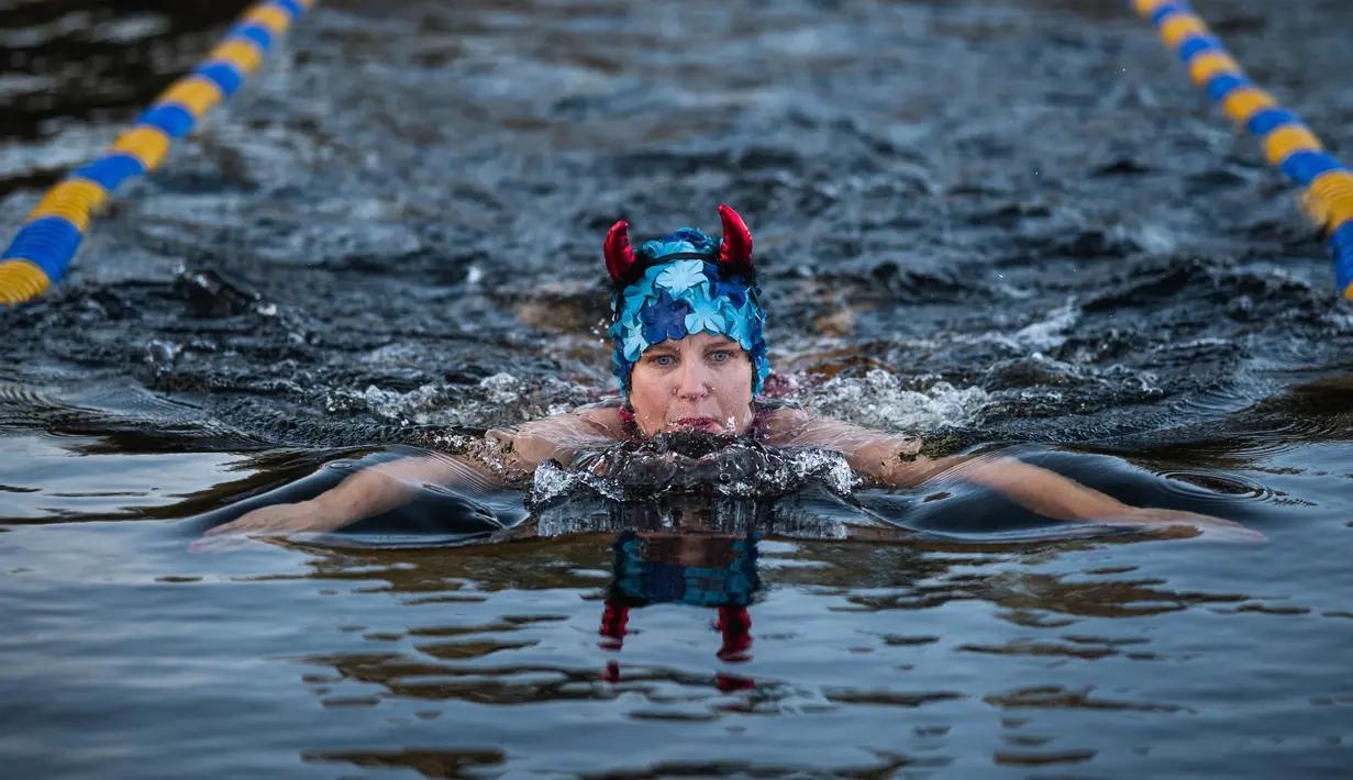 Seorang perempuan berpartisipasi dalam Kejuaraan Berenang Musim Dingin Swedia di Hellasgarden, Stockholm pada 5 Februari 2022. Kejuaraan renang tersebut digelar dengan suhu air tidak lebih dari 1,9 derajat celsius. (Jonathan NACKSTRAND / AFP)