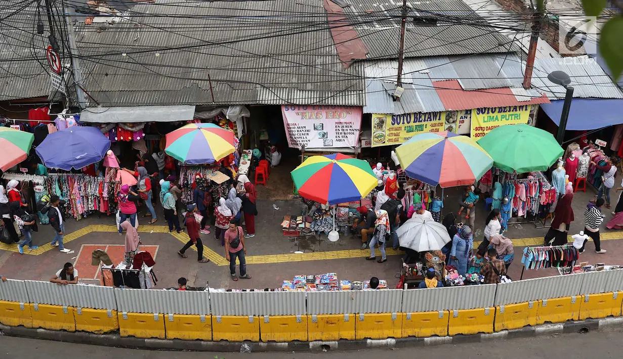 Aktivitas jual beli pedagang kaki lima (PKL) di depan Stasiun Tanah Abang, Jakarta, Kamis (3/5). Diberikannya izin berjualan di kawasan tersebut menyebabkan fungsi trotoar dan jalan raya beralih fungsi. (Liputan6.com/Immanuel Antonius)
