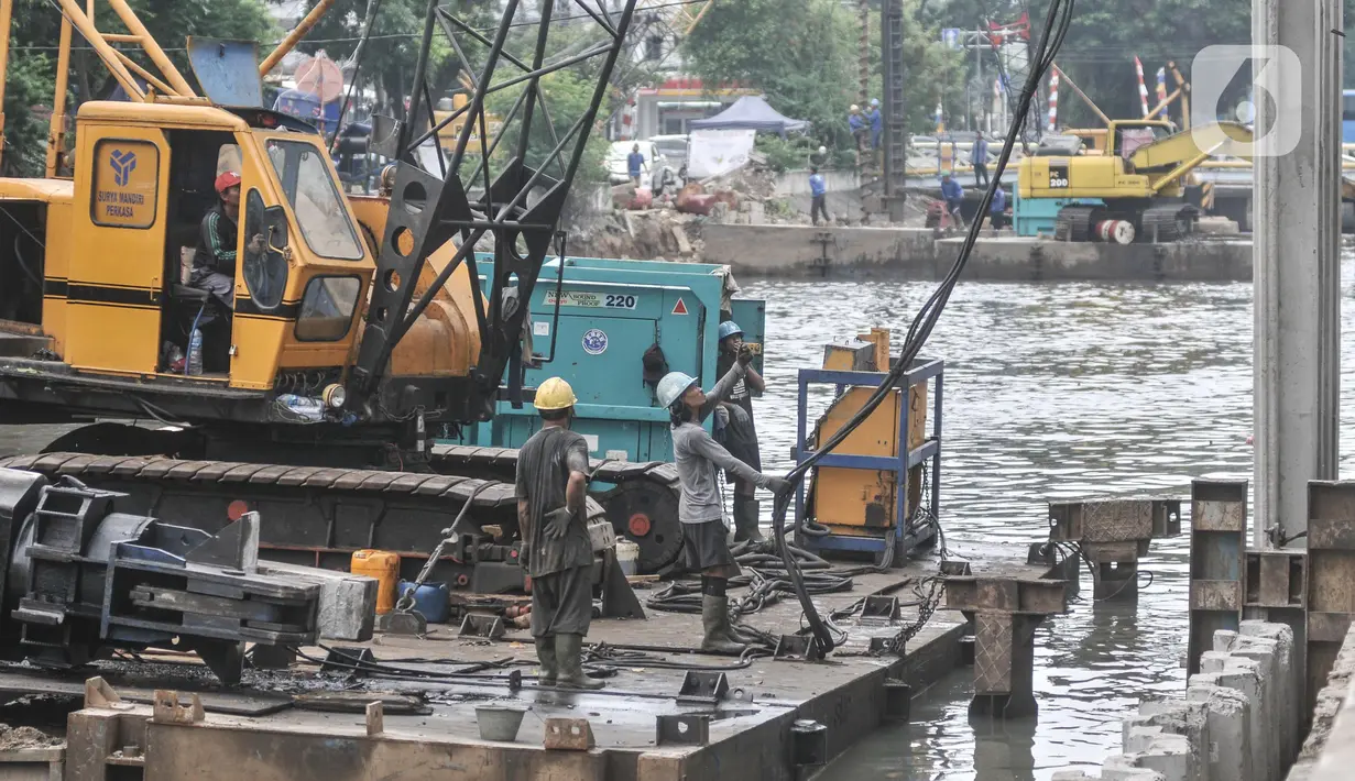 Pekerja dari Dinas Sumber Daya Air (SDA) Provinsi DKI Jakarta menggunakan kendaraan alat berat saat menyelesaikan proyek normalisasi Kali Ciliwung di Jalan Gunung Sahari, Jakarta Pusat, Senin (22/8/2022). Pemprov DKI Jakarta melalui Dinas SDA memastikan program normalisasi Kali Ciliwung terus berjalan dengan prioritas di lokasi aliran utama sungai dan tujuh kelurahan yang merupakan titik rawan banjir. (merdeka.com/Iqbal S. Nugroho)