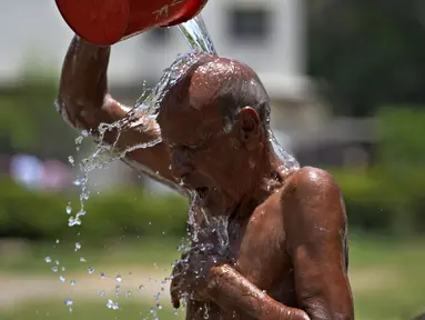 Seorang pria mendinginkan diri di tengah cuaca panas di sebuah taman di Karachi, Pakistan, Selasa (21/5/2024). (AP Photo/Fareed Khan)