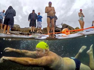 Seorang anggota klub renang Maroubra Winter Seals bersiap-siap menyelam di perairan dingin di Pantai Maroubra, Sydney, Australia, (19/7/2016). (Reuters/David Gray)