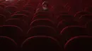 Seorang perempuan memakai masker saat dia menunggu untuk menonton film di dalam aula bioskop Beltrade, di Milan, Senin (26/4/2021). Italia kembali dibuka secara bertahap pada hari Senin setelah enam bulan memberlakukan lockdown untuk menghambat penyebaran Covid-19. (AP Photo/Antonio Calanni)