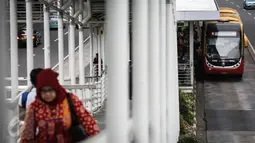 Bus Transjakarta berhenti di Halte Ratu Plaza, Jakarta, Selasa (5/4). Dinas Perhubungan dan Transportasi DKI Jakarta sudah menyiapkan ratusan bus tambahan gratis dalam rangka uji coba penghapusan kebijakan three in one. (Liputan6.com/Faizal Fanani)