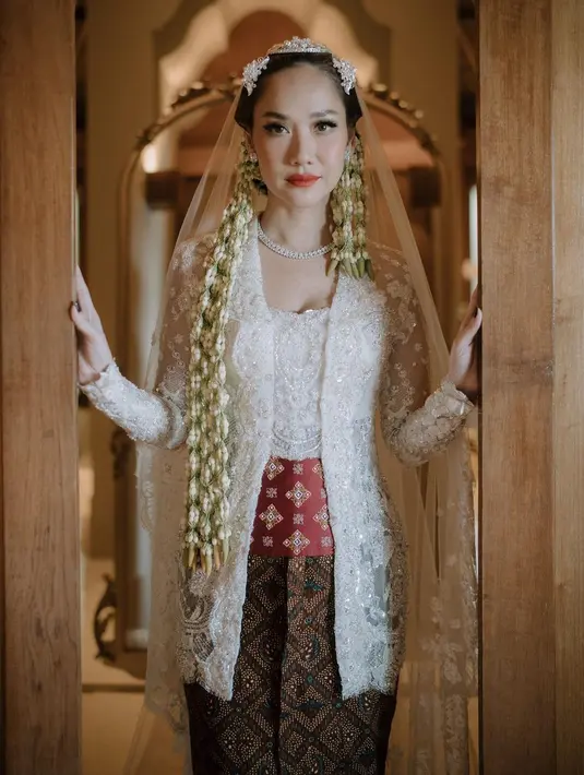 Penampilannya semakin menarik perhatian karena memadukan sanggul dan roncean melati khas jawa dengan veil atau penutup kepala yang menjuntai di belakangnya. [Foto: IG/@itsmebcl/@iluminen]