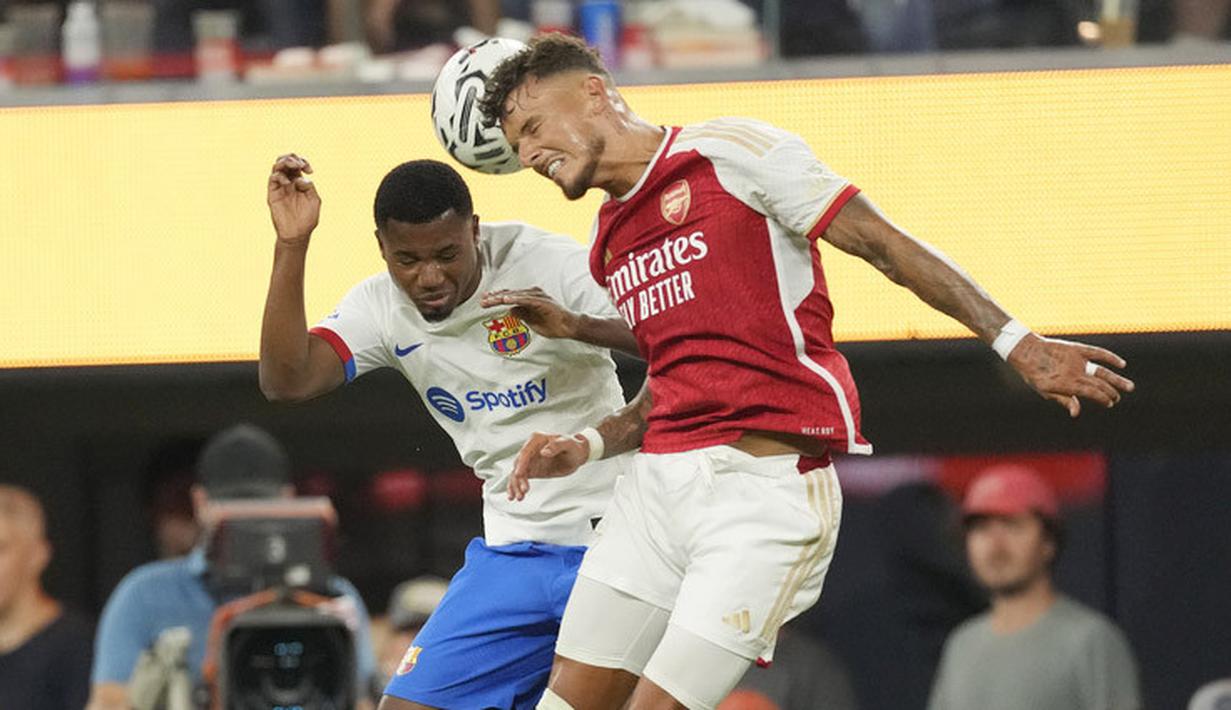 Pemain Barcelona, Ansu Fati, duel udara dengan pemain Arsenal, Ben White, dalam laga pramusim di Stadion SoFi, Inglewood, California, Kamis (27/7/2023). Arsenal menang dengan skor 5-3 atas Barcelona. (AP Photo/Ashley Landis)
