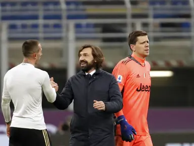 Pelatih Juventus, Andrea Pirlo (tengah) tersenyum dengan Federico Bernardeschi usai pertandingan lanjutan Liga Serie A Italia melawan AC Milan di stadion San Siro, Rabu (7/1/2021). Rekor tak terkalahkan AC Milan patah. Rossoneri takluk 1-3 dari Juventus. (AP Photo/Antonio Calanni)