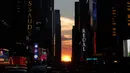 Matahari terbenam di antara pencakar langit ketika fenomena Manhattanhenge di 42nd street di Times Square, New York City, Kamis (12/7). Fenomena manhattanhenge terjadi dimana saat matahari terbenam sejajar dengan jalan. (AFP/TIMOTHY A. CLARY)