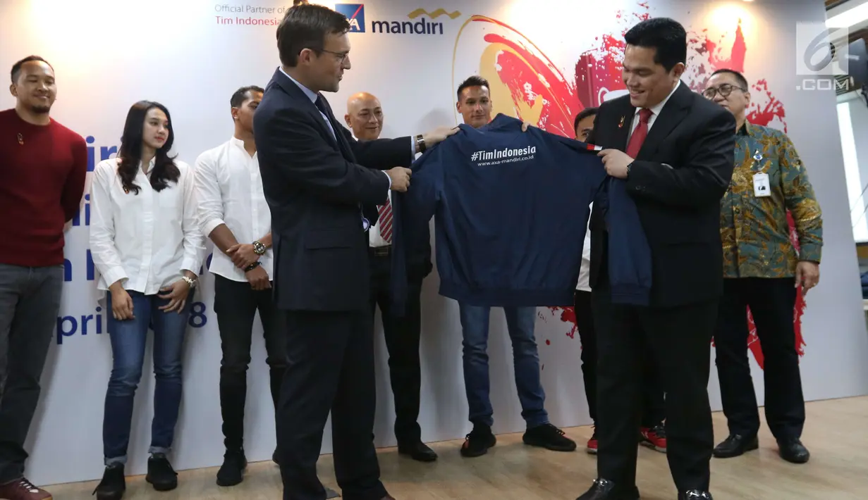 President Director of AXA Mandiri, Jean-Philippe Vandenschrick (kiri) bersama Ketum Komite Olimpiade Indonesia (KOI) Erick Thohir menunjukkan jaket usai menandatangani perjanjian kerja sama di AXA Tower, Jakarta, Senin (23/4). (Liputan6.com/Angga Yuniar)