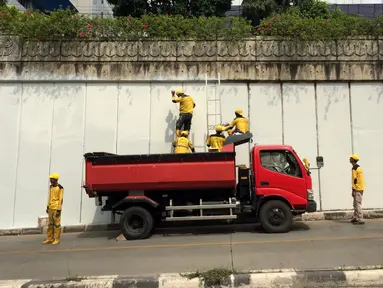 Pasukan Kuning mengecat dinding Underpass Kebayoran Baru, Jakarta Selatan, Kamis (1/2). Pengecatan dilakukan sebagai bentuk perawatan. (Liputan6.com/Immanuel Antonius)