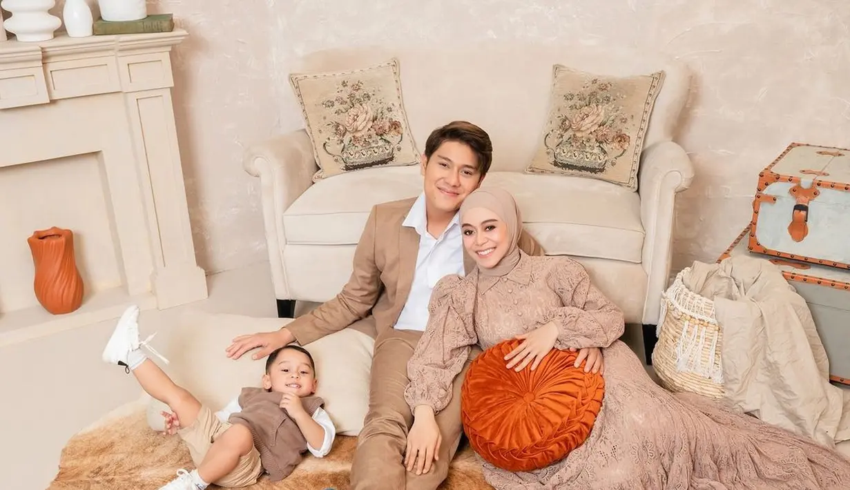 Potret gemas keluarga Rizky Billar dan Lesti Kejora. Rizky Billar tampil mengenakan setelan jas dan celana panjang cokelat, dan kemeja putih. Sedangkan Lesti tampil anggun dengan gamis cokelat yang serasi dan cantik, dipadu hijab cokelat yang senada. [Foto: Instagram/rizkybillar]