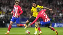 Pemain Atletico Madrid, Rodrigo De Paul, berusaha mengadang pemain Borussia Dortmund, Jadon Sancho, pada leg pertama perempat final Liga Champions di Stadion Metropolitano, Kamis (11/4/2024). (AP Photo/Manu Fernandez)