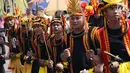 Pemuda peduli Nias melakukan atraksi tarian perang di kawasan Jalan Jenderal Sudirman, Jakarta, Minggu (4/3). Pemuda Peduli Nias melakukan beragam atraksi budaya untuk mempromosikan pariwisata di pulau tersebut. (Liputan6.com/Helmi Fithriansyah)