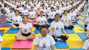 Sejumlah orang melakukan gerakan yoga di Zhenjiang, Provinsi Jiangsu, Cina, (20/6). Sejumlah negara di dunia sedang merayakan Hari Yoga Dunia yang jatuh pada tanggal 21 Juni. (REUTERS/Stringer)