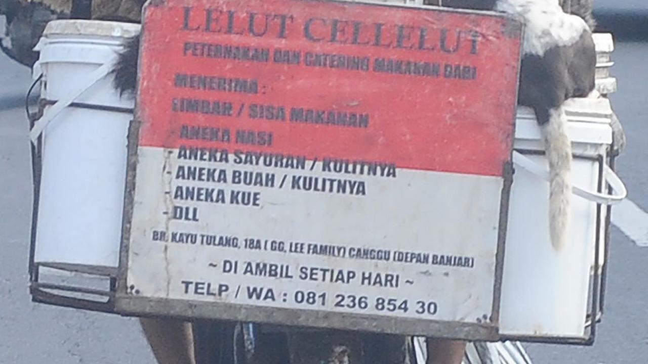 Di belakang sepeda motornya, Lelut juga memasang sebuah plang yang ia ditulis menerima limbah sisa makanan.