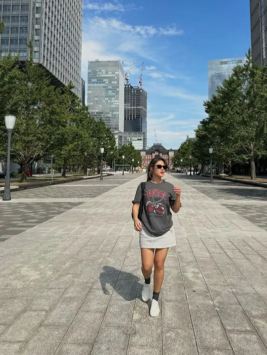 Ia memadukan graphic oversized shirt dengan rok mini dan sneakers putih serta kaus kaki abu-abu [@raisa6690]